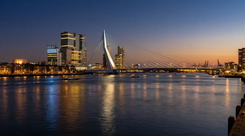 Erasmus Bridge and Rotterdam skyline at dusk from the riverbank