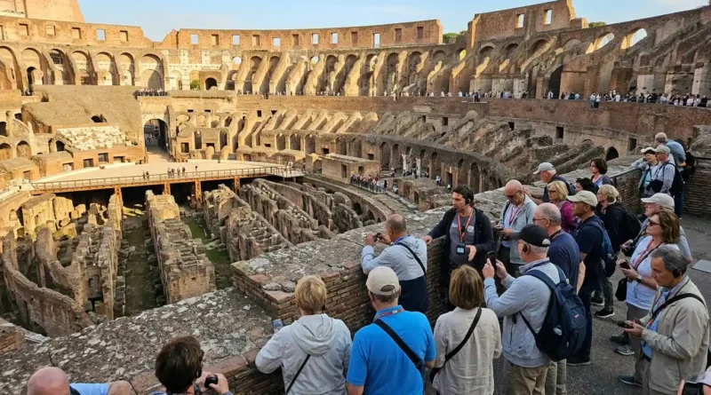 Visitors on a guided Rome Coliseum tour looking at the arena floor from the upper levels