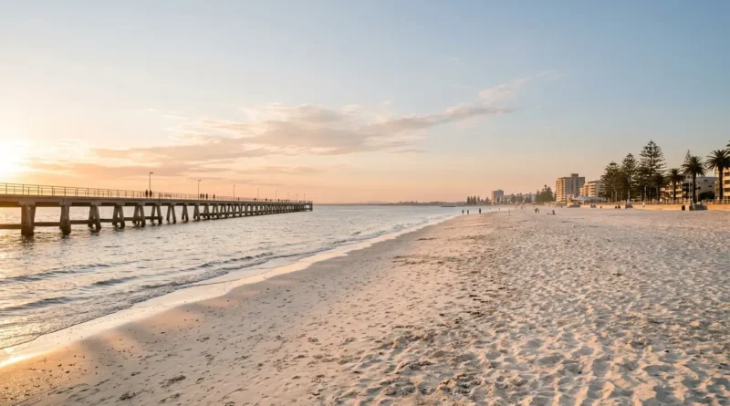 Wide sandy curve of Glenelg Beach in Adelaide with the jetty and late afternoon light